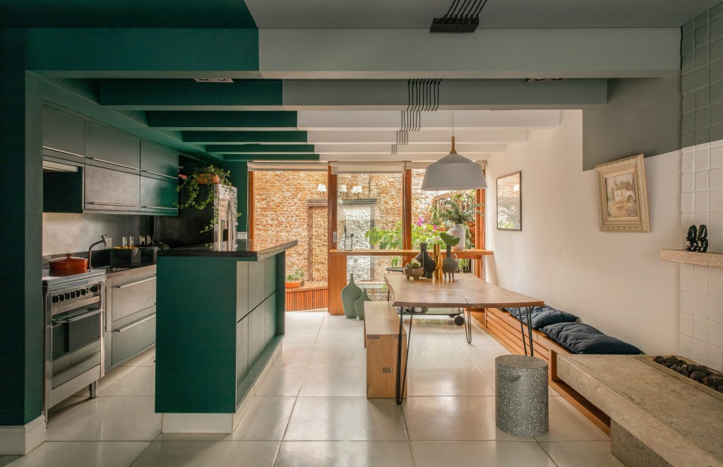 Projeto de Ricardo Abreu. Na foto, cozinha integrada com sala de jantar com ilha verde e teto verde.