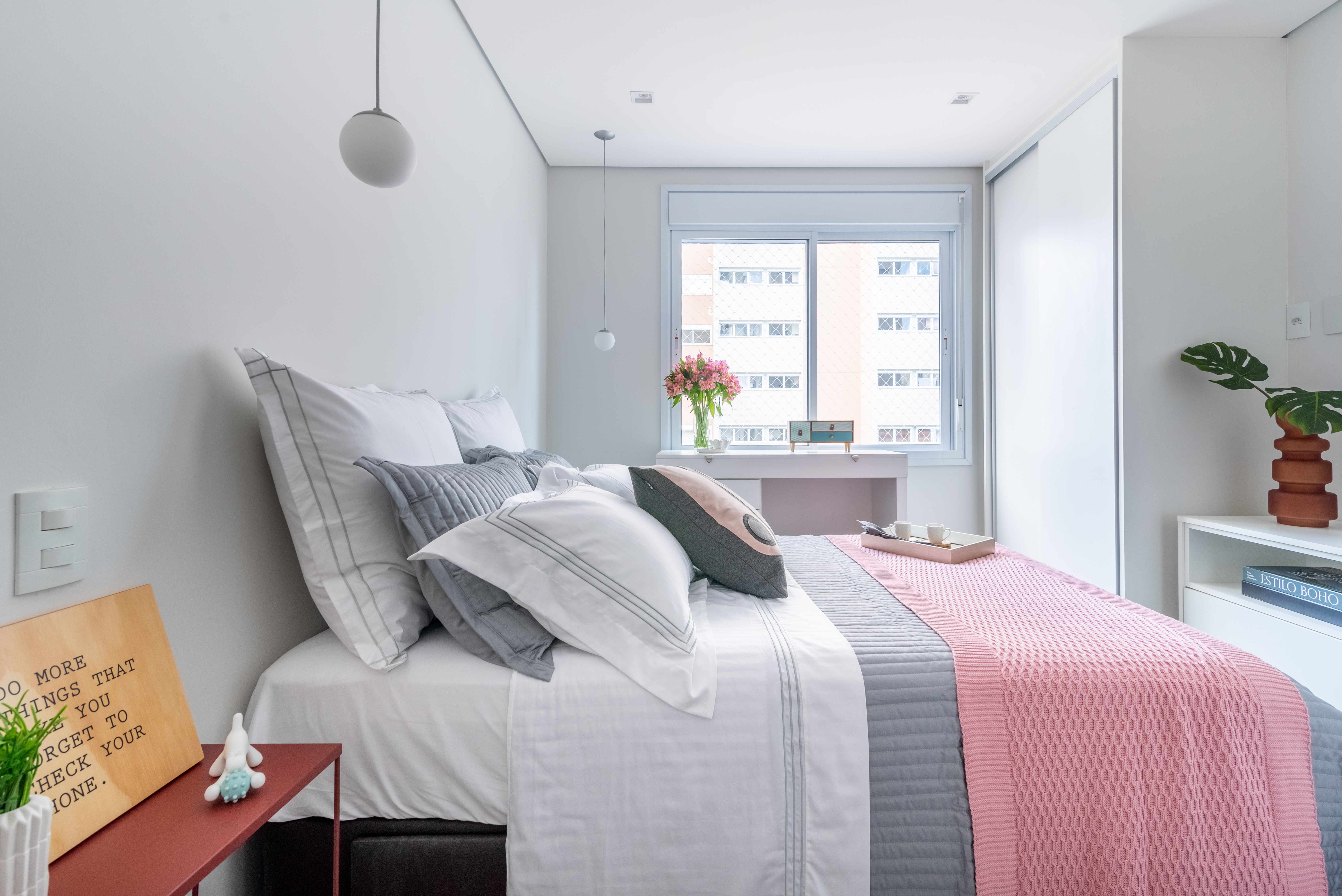 Projeto de Isabella Nalon. Na foto, quarto com cama de casal e armário branco com espelho na porta.
