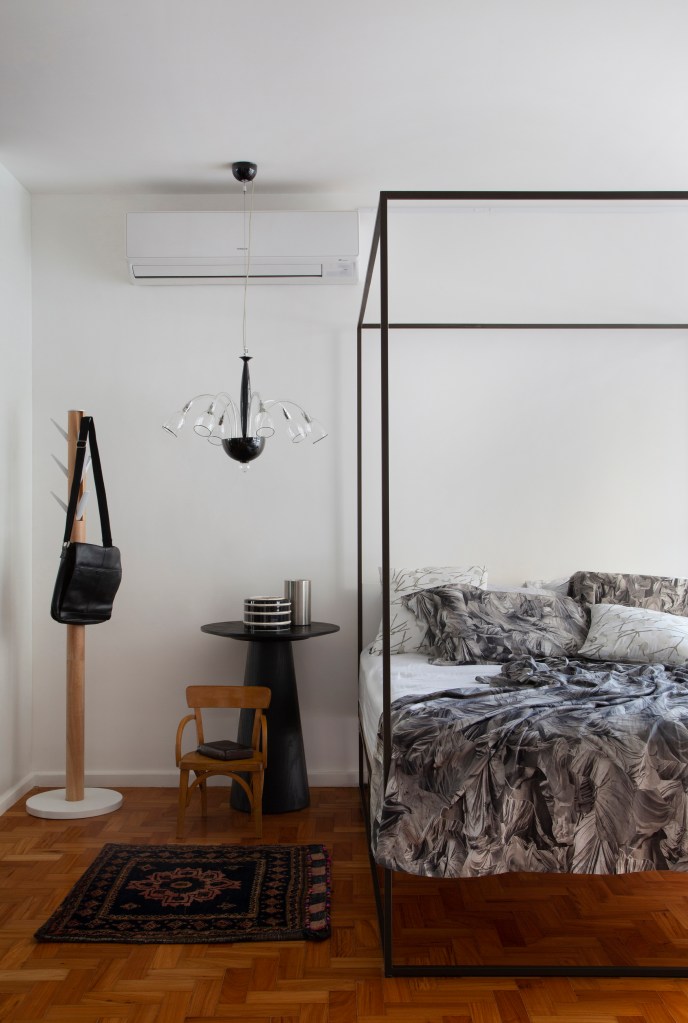 Projeto de Ricardo Melo e Rodrigo Passos. Na foto, quarto com cama de casal com dossel e cabideiro.