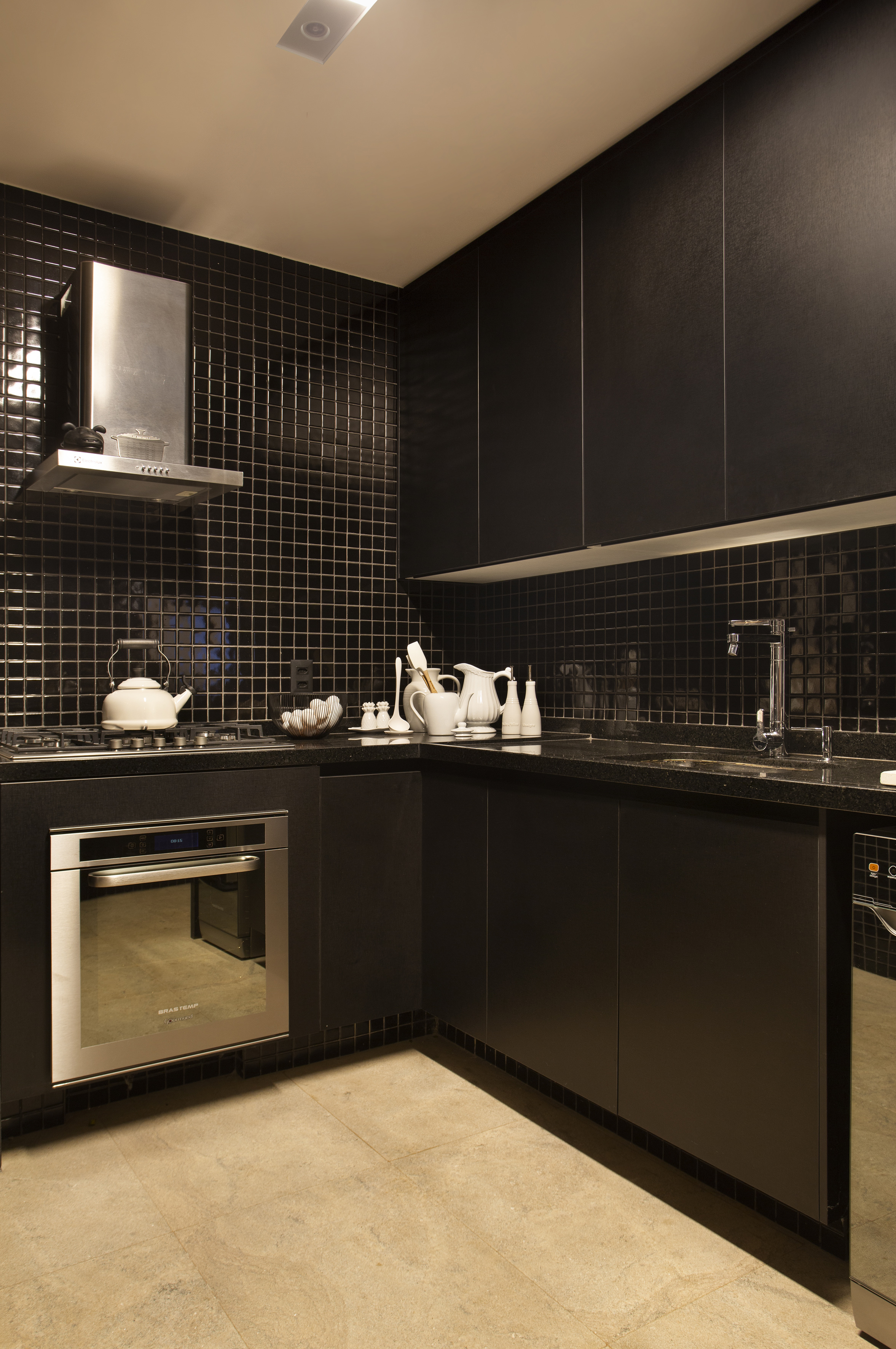 Projeto de Ricardo Melo e Rodrigo Passos. Na foto, cozinha com marcenaria e revestimentos pretos.