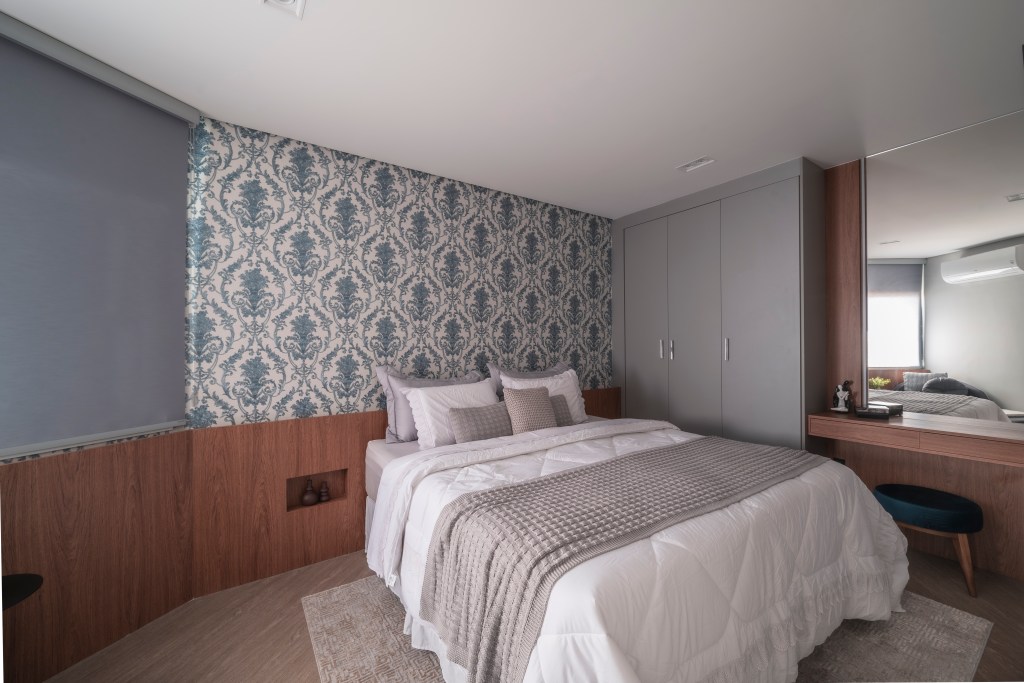 Projeto de PB Arquitetura. Na foto, quarto com cama de casal, cabeceira de madeira e papel de parede.