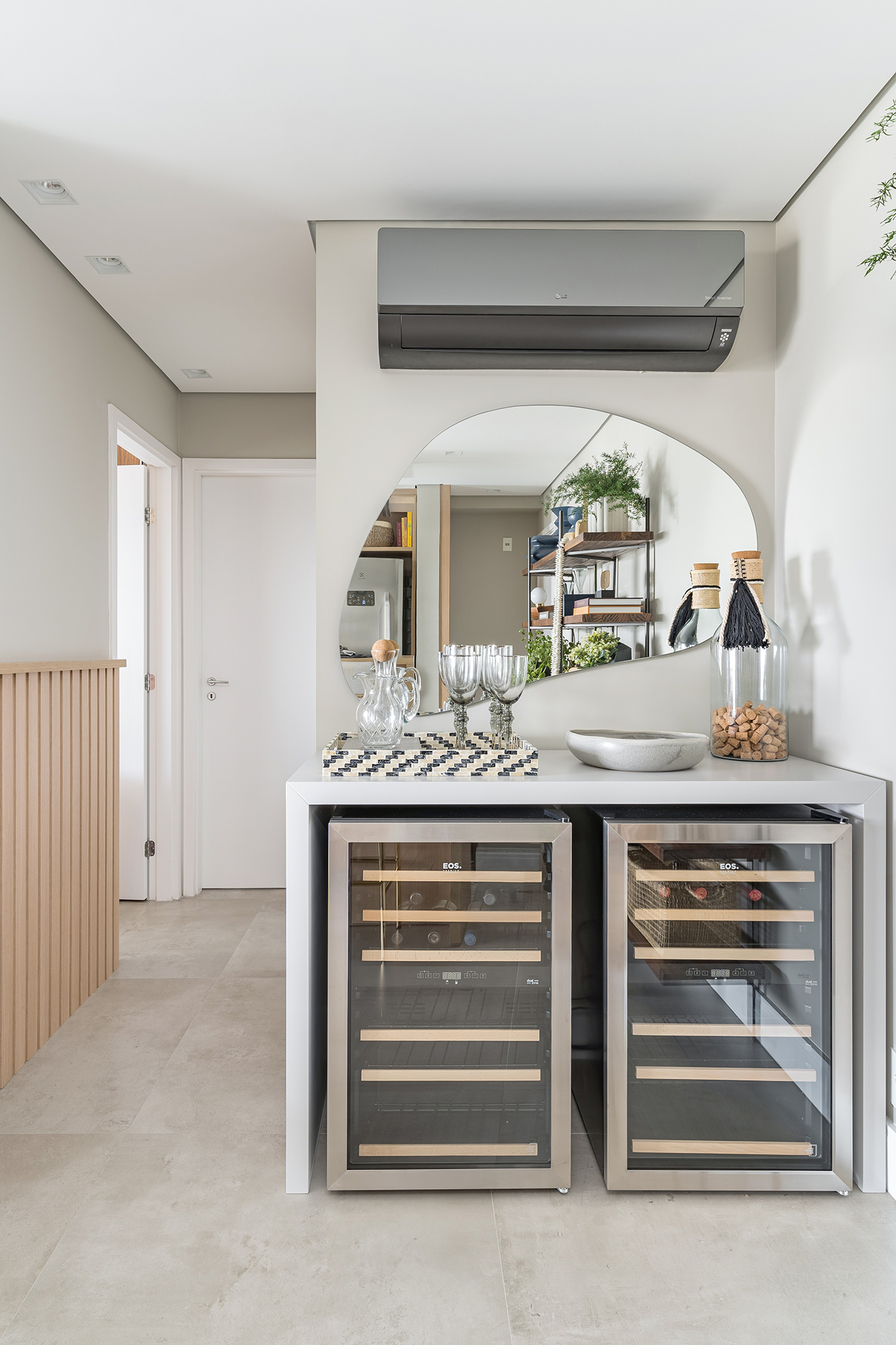 Apartamento de 60 m² ganha décor delicado repleto de madeira e plantas. Projeto de Bia Hajnal. Na foto, bar com adega e espelho orgânico.