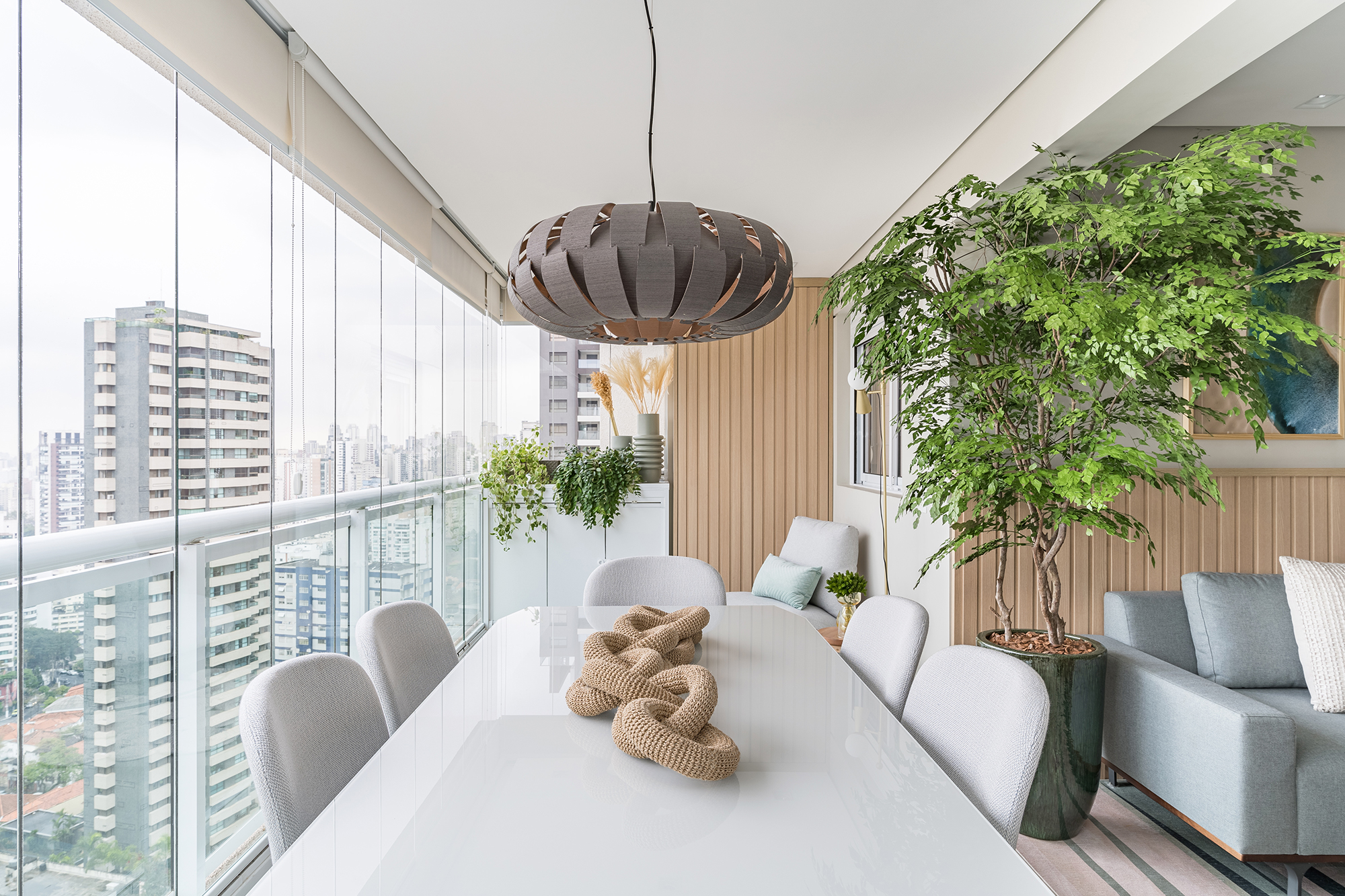 Apartamento de 60 m² ganha décor delicado repleto de madeira e plantas. Projeto de Bia Hajnal. Na foto, varanda com cantinho de leitura e plantas.