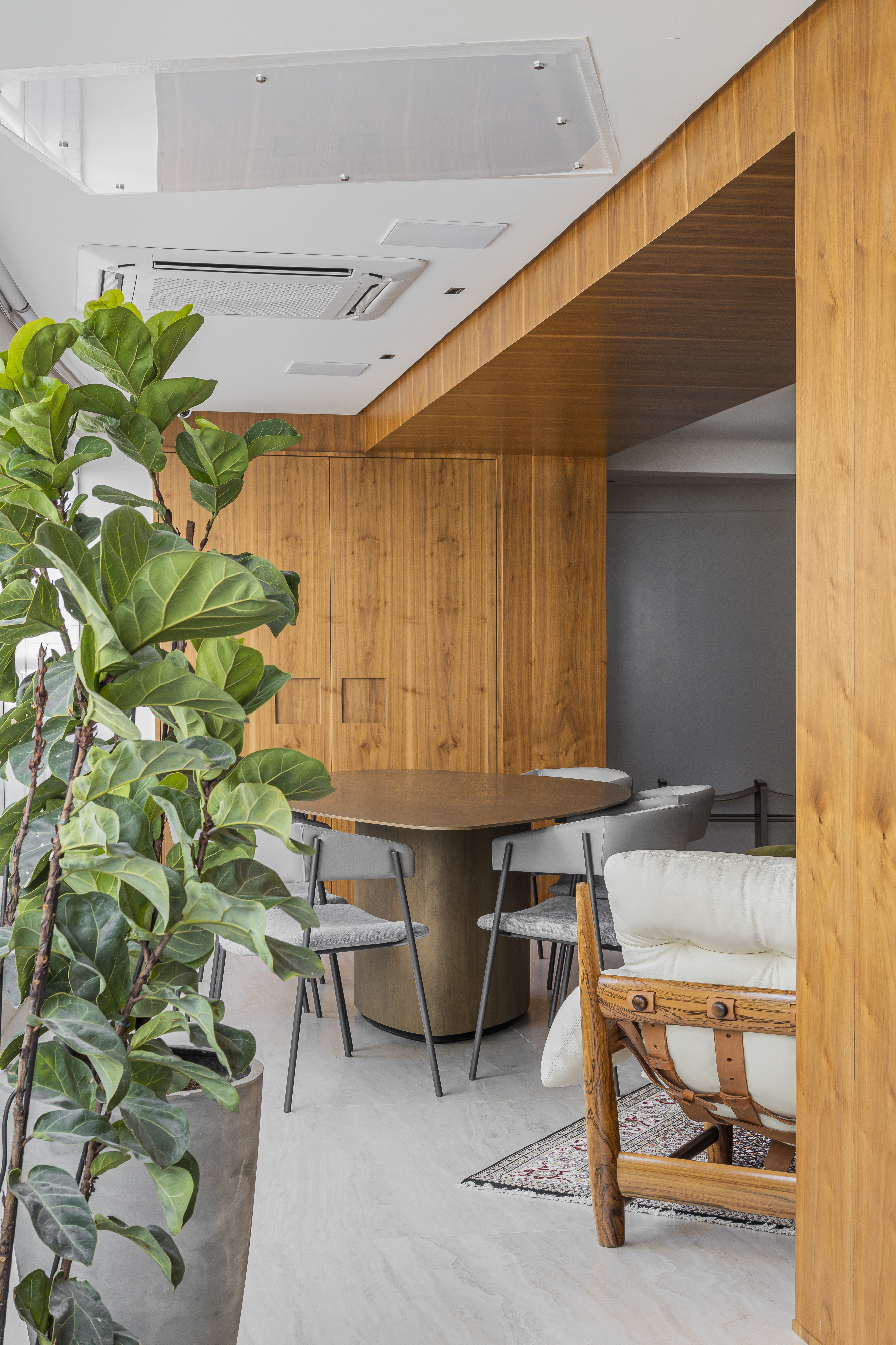 Projeto de Romário Rodrigues. Na foto, varanda integrada com mesa em formato orgânico e plantas.