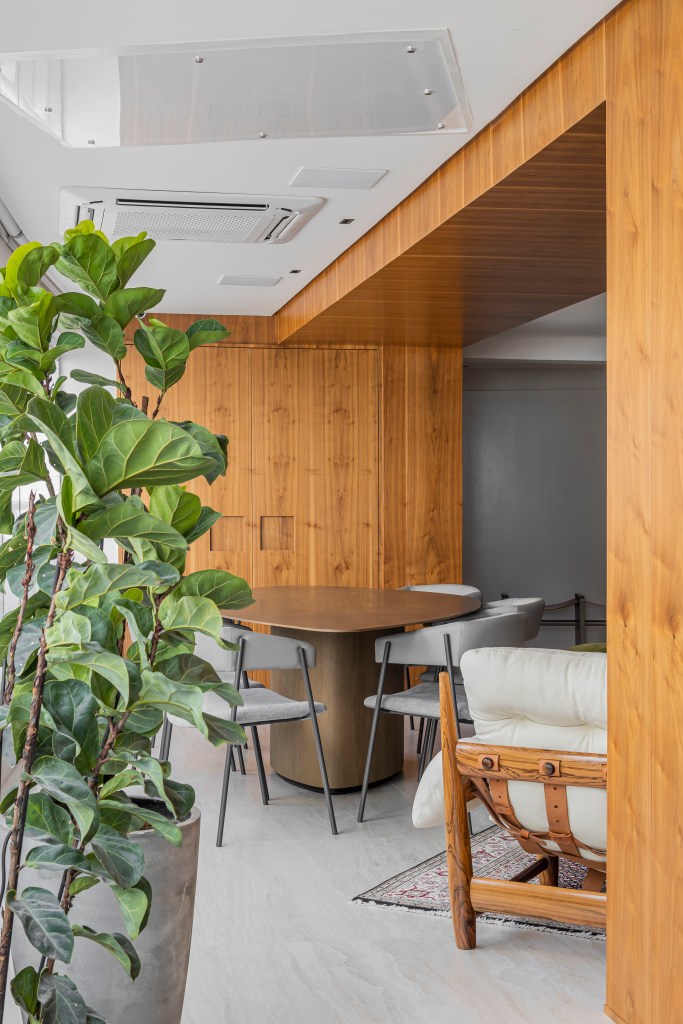 Projeto de Romário Rodrigues. Na foto, varanda integrada com mesa em formato orgânico e plantas.