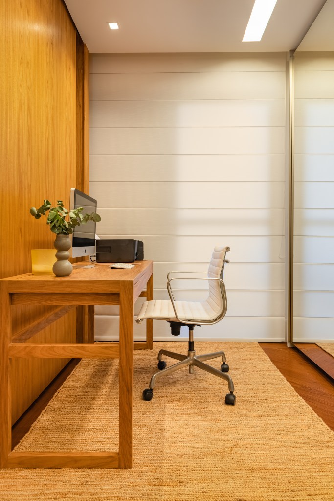 Projeto de Fernanda Dabbur. Na foto, home office pequeno com mesa de madeira e persiana.