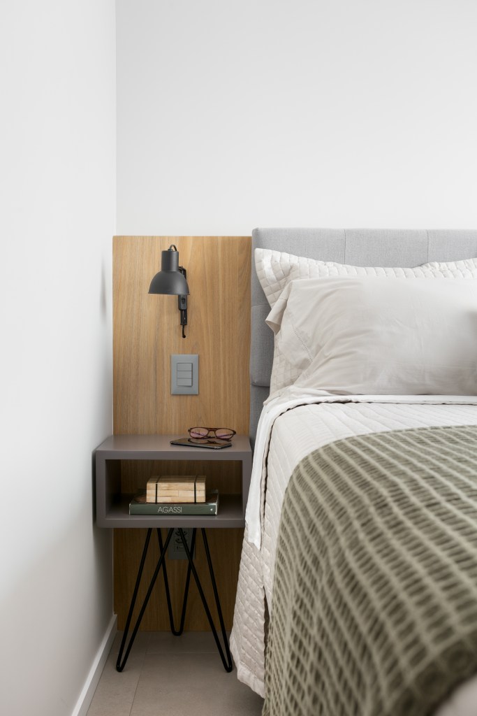 Projeto de Studio Dyo. Na foto, quarto com cama de casal e cabeceira de madeira.