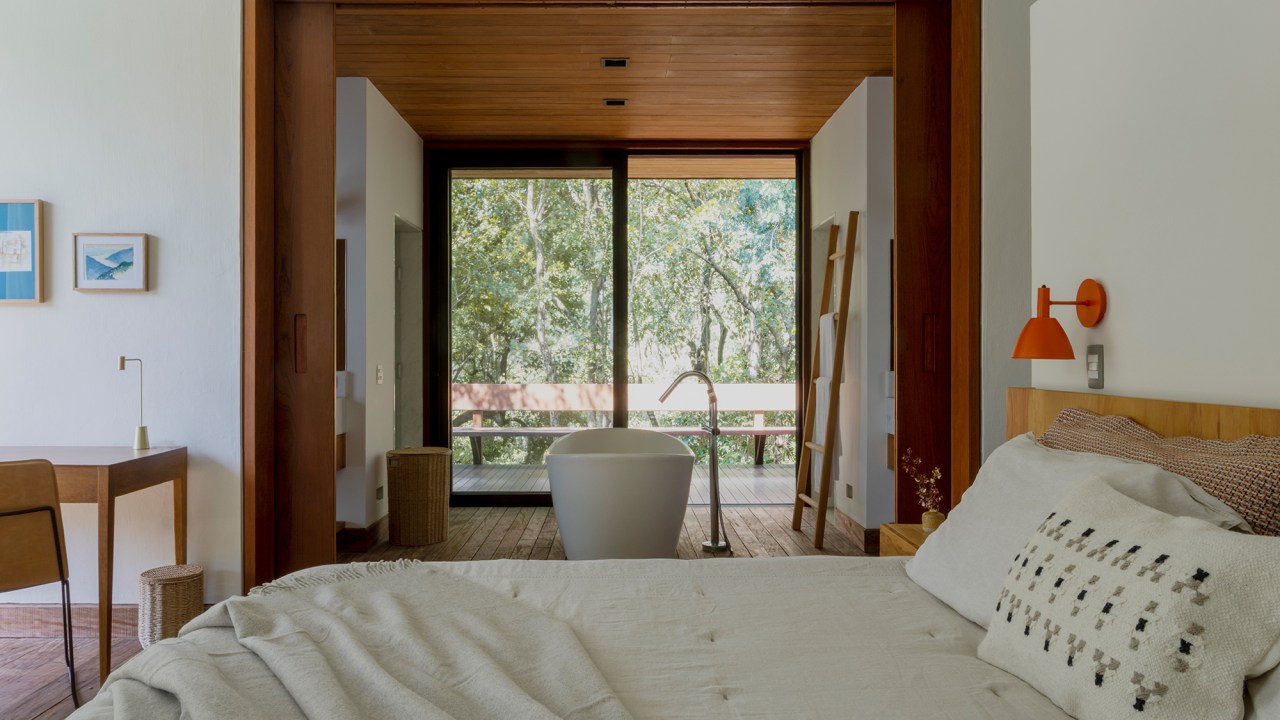 Casa de campo de 818 m² é um verdadeiro refúgio em meio à natureza. Projeto de Daniel Fromer. Na foto, banheira com vista para o jardim. Quarto de casal.
