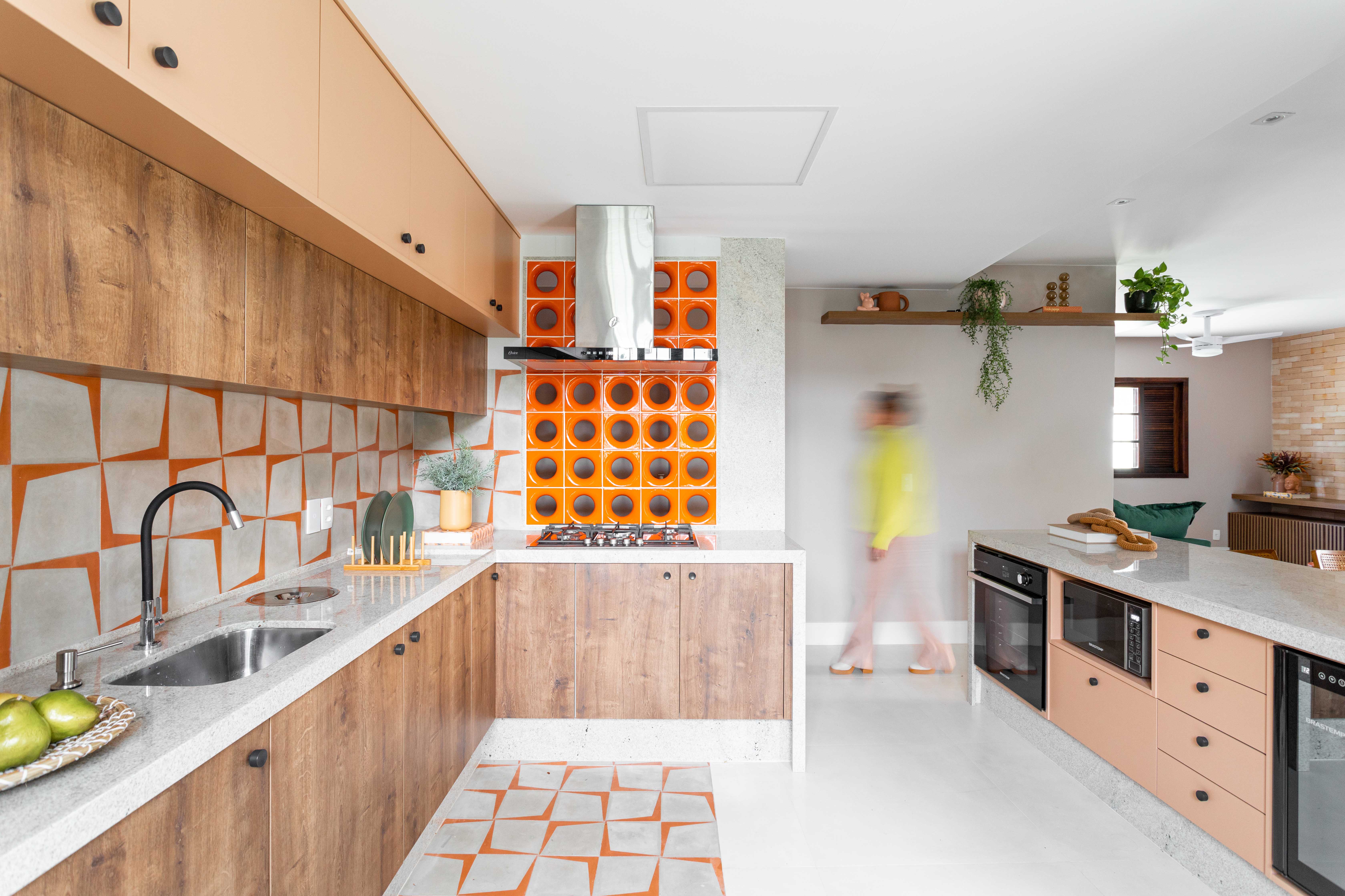 Projeto de Lívia Ornellas. Na foto, cozinha com cobogós laranjas, ladrilhos laranjas, marcenaria e bancada branca.