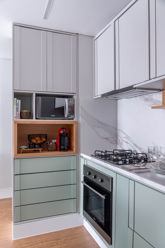 Como organizar utensílios e mantimentos nos armários da cozinha. Projeto de Carina Dal Fabbro. Na foto, cozinha integrada com backsplash marmorizado.