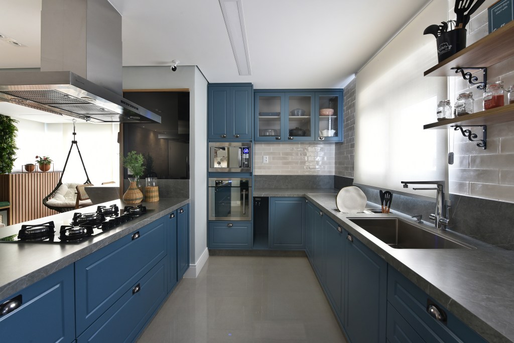 Como organizar utensílios e mantimentos nos armários da cozinha. Projeto de Carina Dal Fabbro. Na foto, cozinha com marcenaria azul.