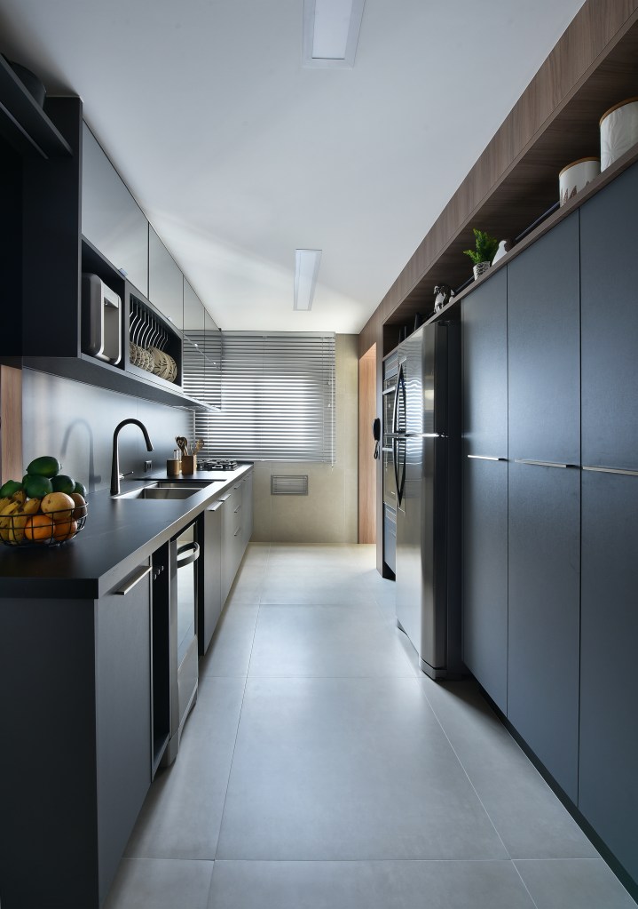 Como organizar utensílios e mantimentos nos armários da cozinha. Projeto de Rosangela Pena. Na foto, cozinha com marcenaria cinza escura.