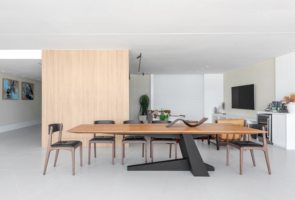 Dois apartamentos unidos criam casa de praia para a família em 370 m². Projeto de Maria Augusta Bittencourt, Na foto, sala de jantar com mesa escultórica.