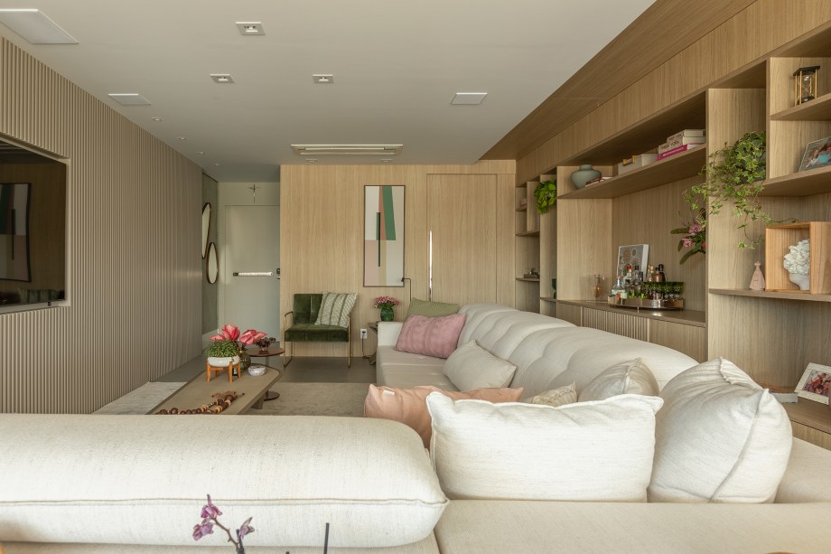 Estante da sala de apartamento de 165 m² une nichos, adega e bar