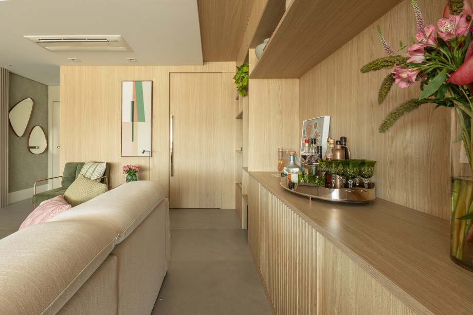 Estante da sala de apartamento de 165 m² une nichos, adega e bar