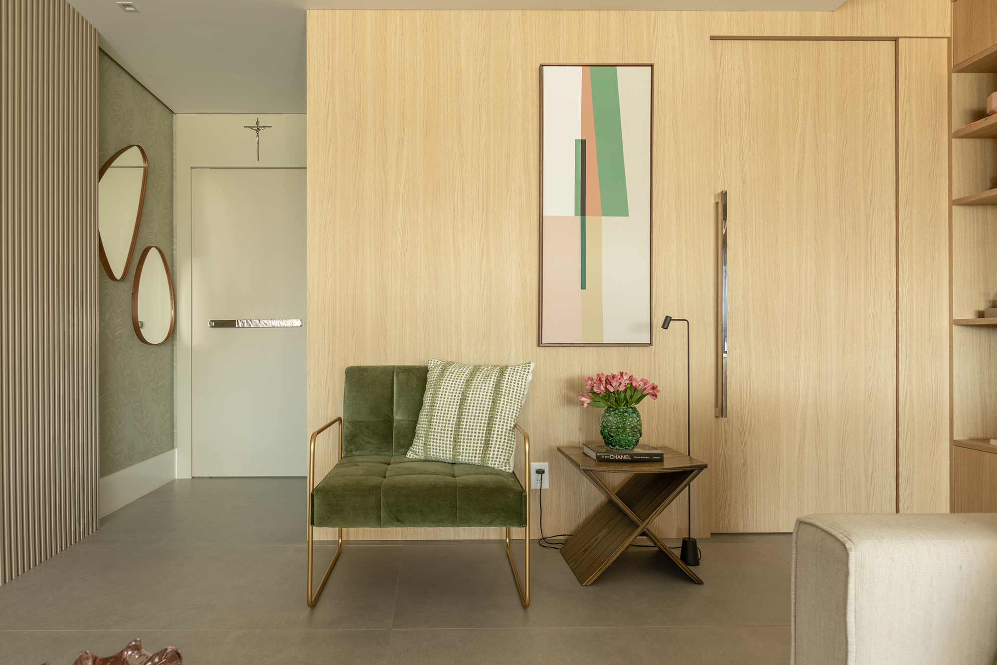 Estante da sala de apartamento de 165 m² une nichos, adega e bar. Projeto de Eliana Souza. Na foto, porta camuflada no painel de madeira.