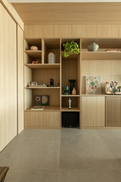 Estante da sala de apartamento de 165 m² une nichos, adega e bar