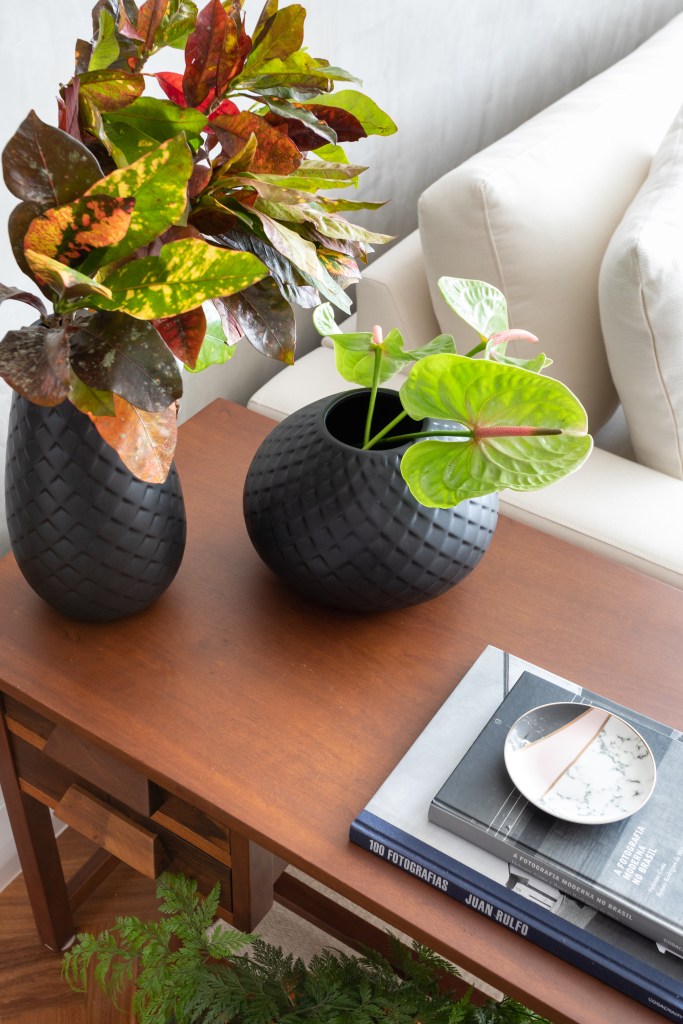 Projeto de Vivi Cirello. Na foto, mesa lateral com vasos de plantas.