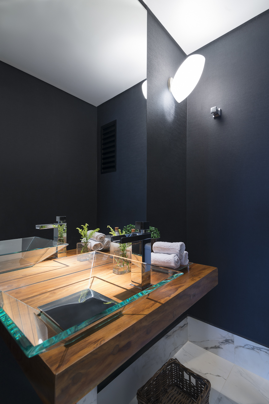 Projeto de Carina Dal Fabbro. Na foto, lavabo com bancada de madeira de demolição, parede preta e cuba de vidro.