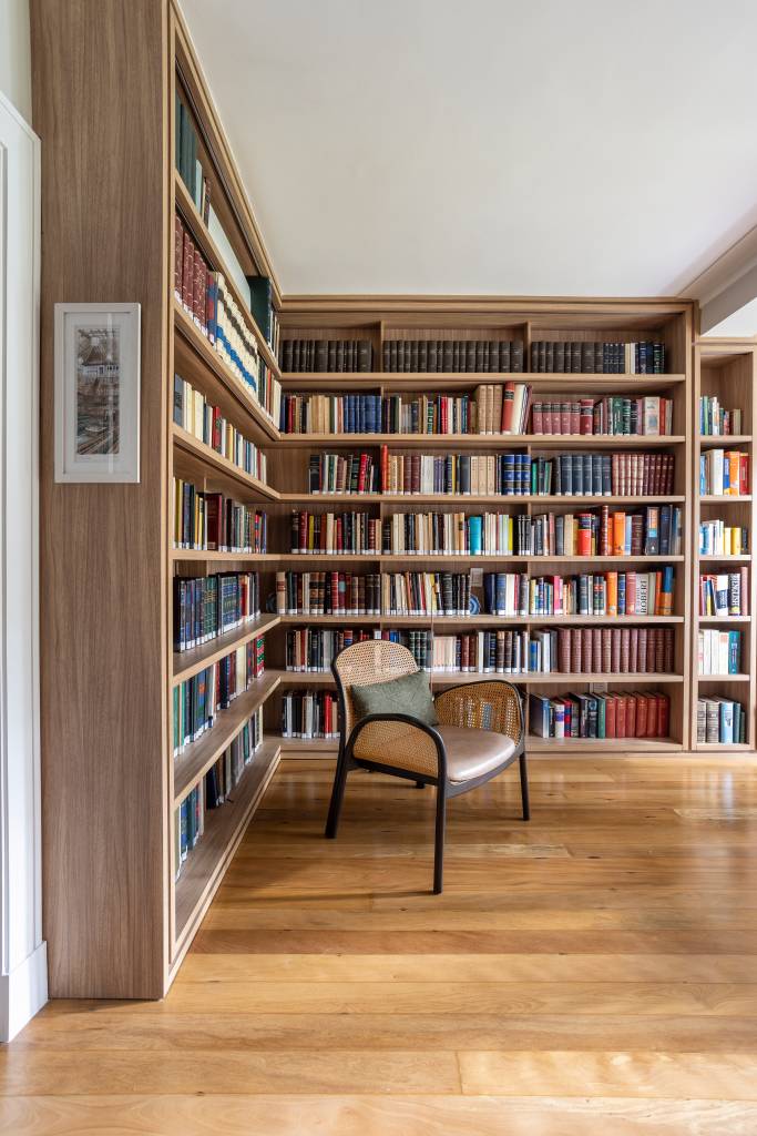 Projeto de Stal Arquitetura. Na foto, home office com estante de livros e mesa de madeira.