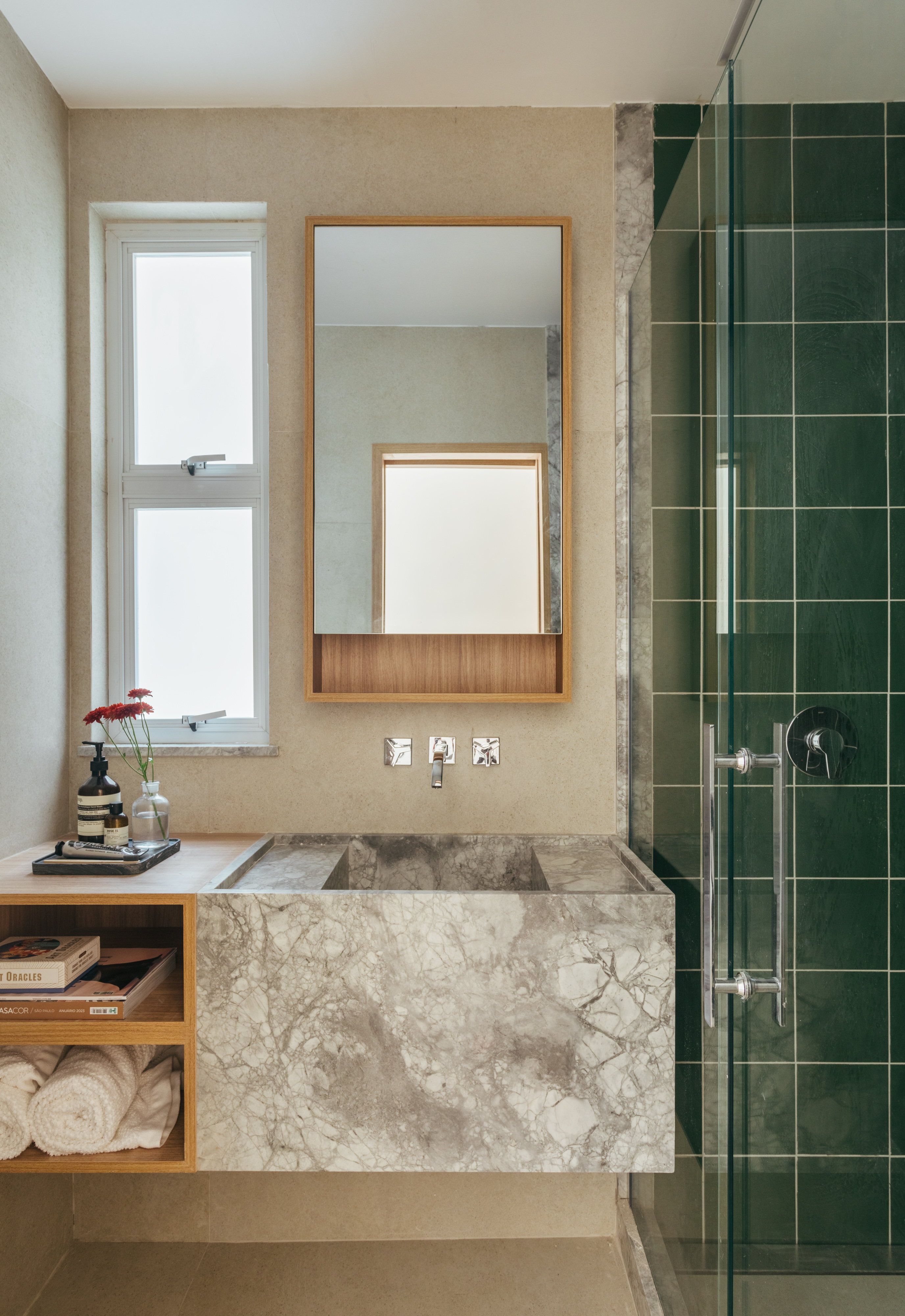 Projeto de Rodolfo Consoli. Na foto, banheiro pequeno com cuba esculpida e box revestido de azulejos verdes.