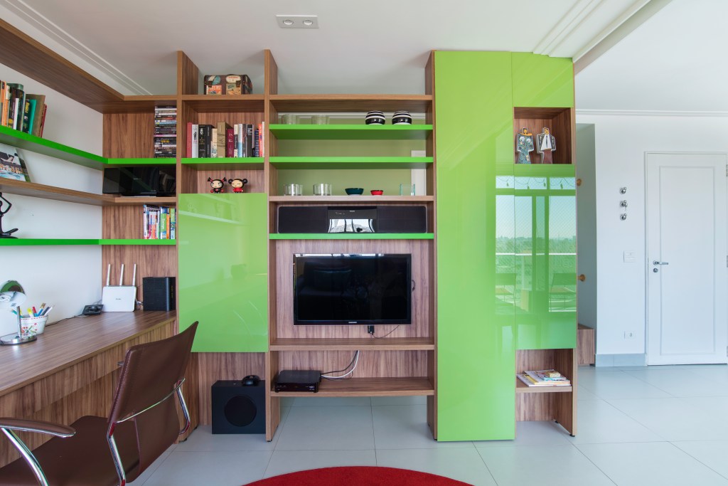 Projeto de Raízes Arquitetos. Na foto, estante verde com espaço para tv.