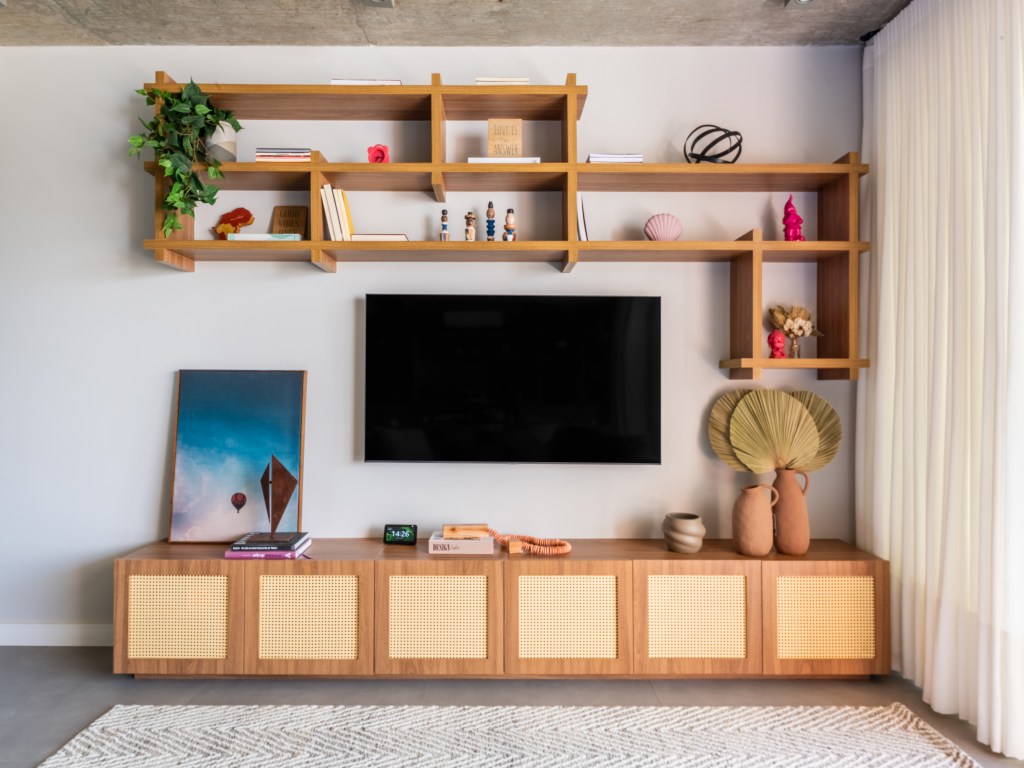 Projeto de BMA Studio. Na foto, sala de tv com rack de madeira e nichos de madeira.