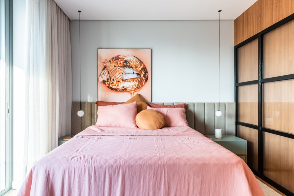 Projeto de BMA Studio. Na foto, quarto com cama de casal, cabeceira acolchoada e cama de casal com roupas de cama rosa.