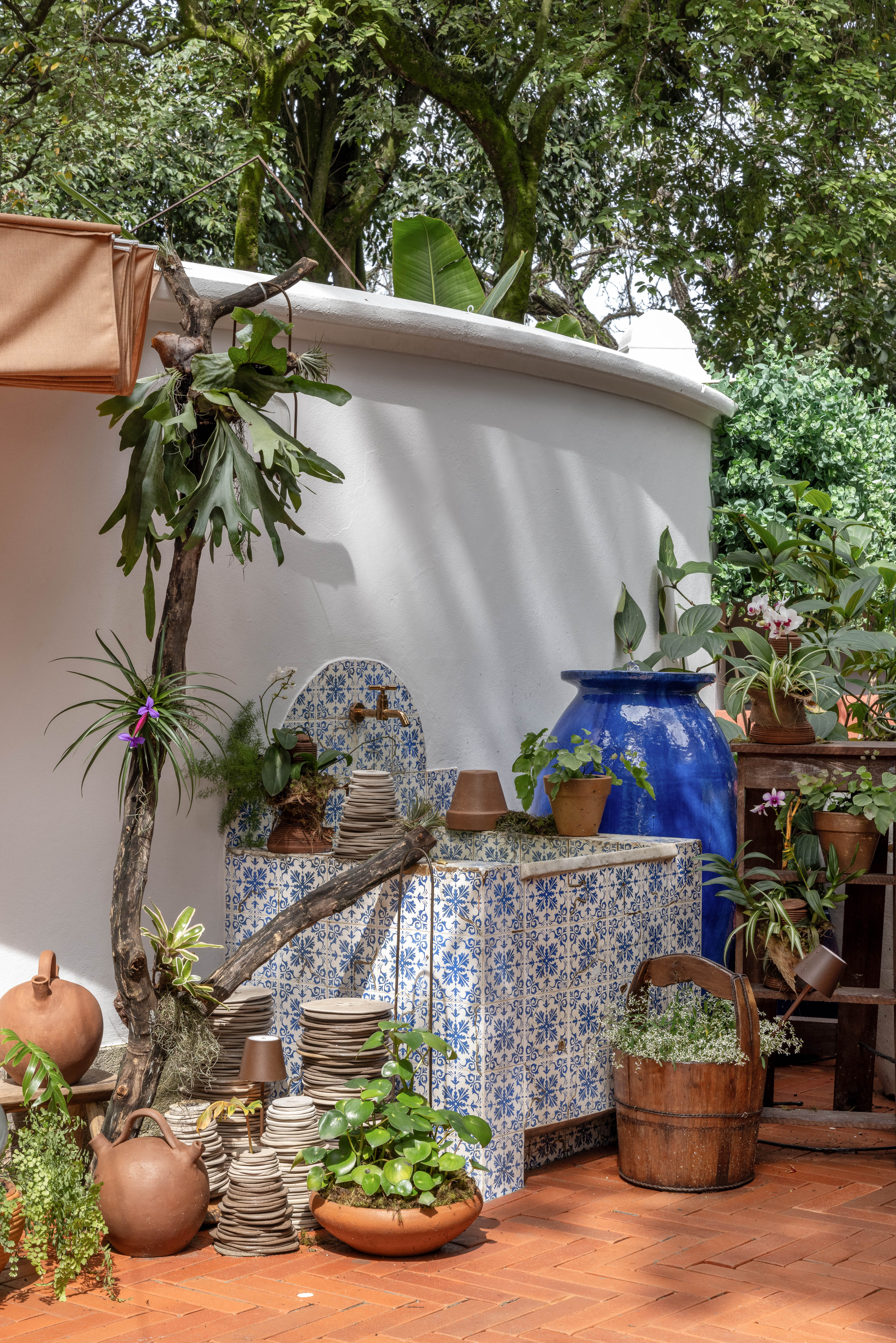 Terraza e loja Cooking To Go - ambiente de Marcela Martins para a CASACOR Rio 2023. Na foto, jardim com vasos grandes azuis e plantas.
