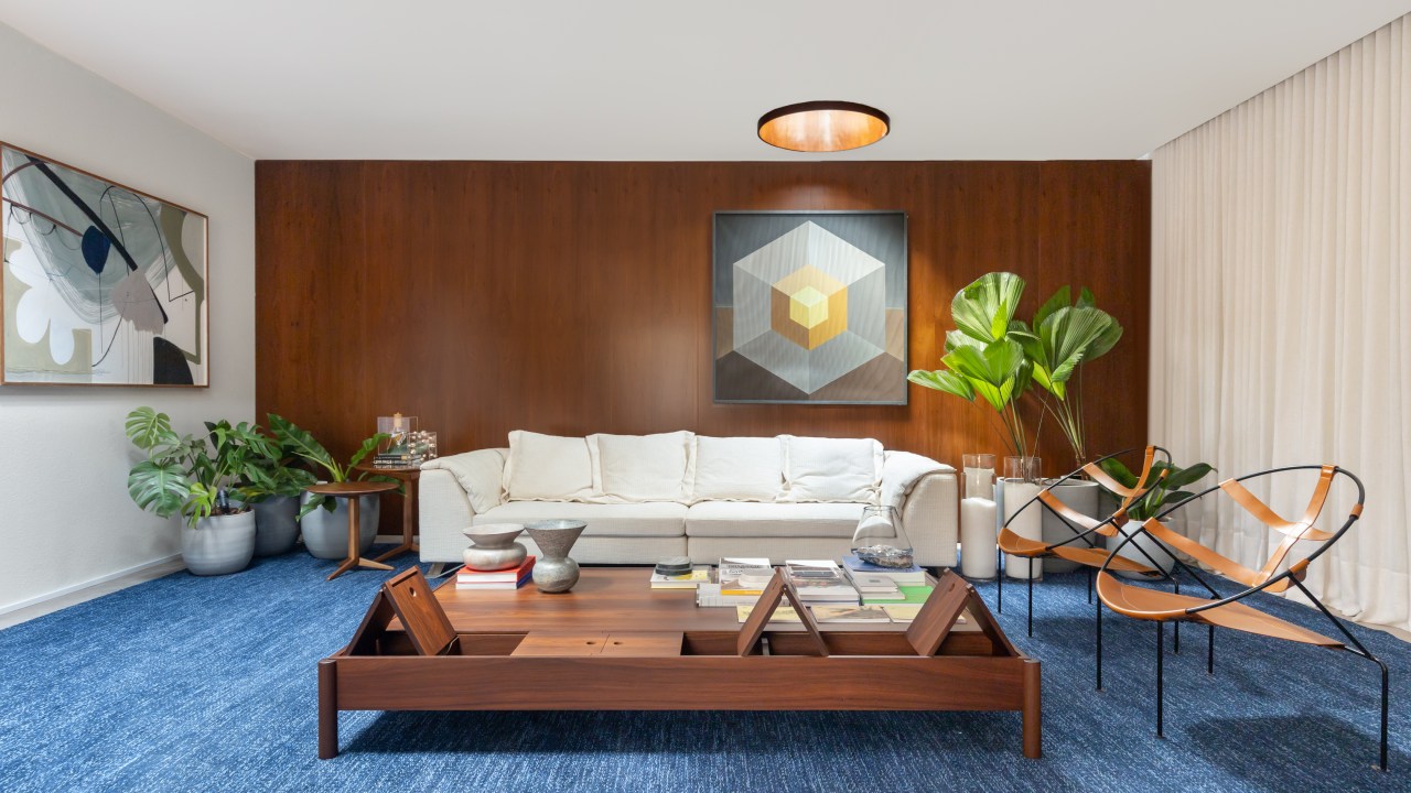 Salas de 60 m² celebram momentos em família e design brasileiro. Projeto de Maria Araujo para a CASACOR Brasilia 2023. Na foto, sala de estar com tapete azul e parede de madeira.