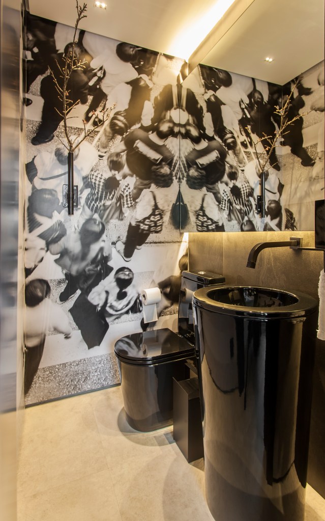 Projeto de Korman Arquitetos. Na foto, lavabo com vaso sanitário e cuba pretos e papel de parede.