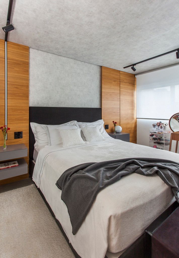 Projeto de Korman Arquitetos. Na foto, quarto com cama de casal e cabeceira preta.