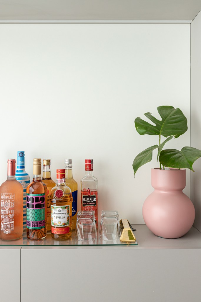 Projeto de Inovando Arquitetura. Na foto, home bar, cantinho de bar com bandeja de bebidas e vaso rosa.