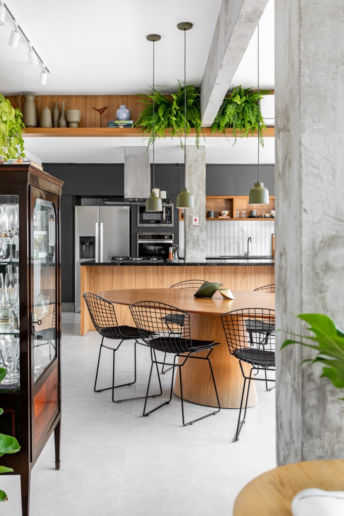 Projeto de Raphael Assaf Arquitetura. Na foto, cozinha integrada com sala de jantar. Viga de concreto e cristaleira.