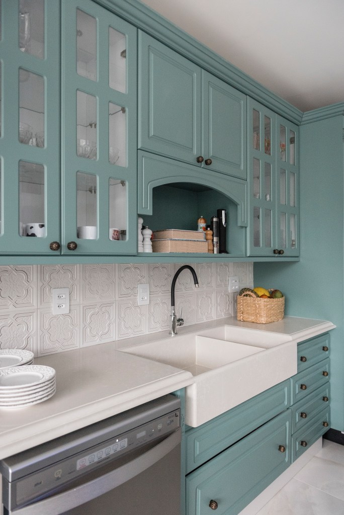 Projeto de PB Arquitetura. Na foto, cozinha em estilo shaker com armários azuis com portas de vidro.