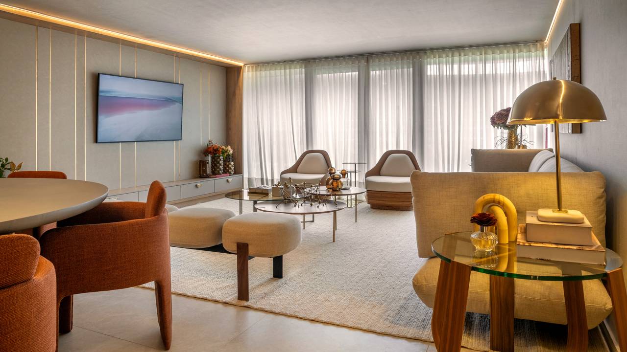 Apartamento de 189 m² tem décor afetivo e repleto de peças autorais. Projeto de Vivian Maia para a CASACOR Brasília 2023. Na foto, sala de estar com tapete. sofá, tv e poltronas.