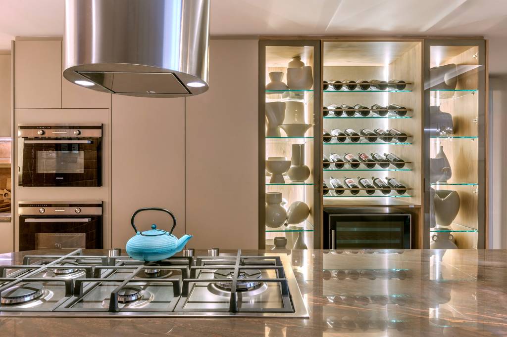 Apartamento de 189 m² tem décor afetivo e repleto de peças autorais. Projeto de Vivian Maia para a CASACOR Brasília 2023. Na foto, cozinha com ilha, adega e coifa redonda.