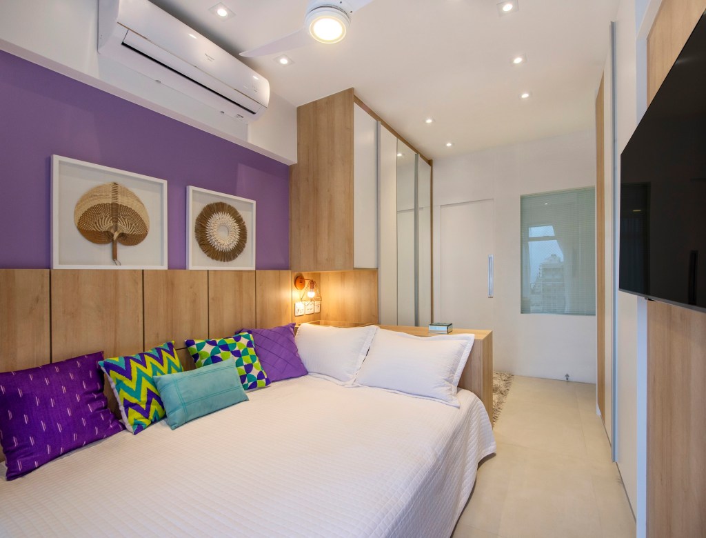 Apartamento de 85 m² tem décor baseada nas cores do chackras. Projeto de Campos & Olivetti Arquitetura. Na foto, quarto com parede violeta e marcenaria planejada.