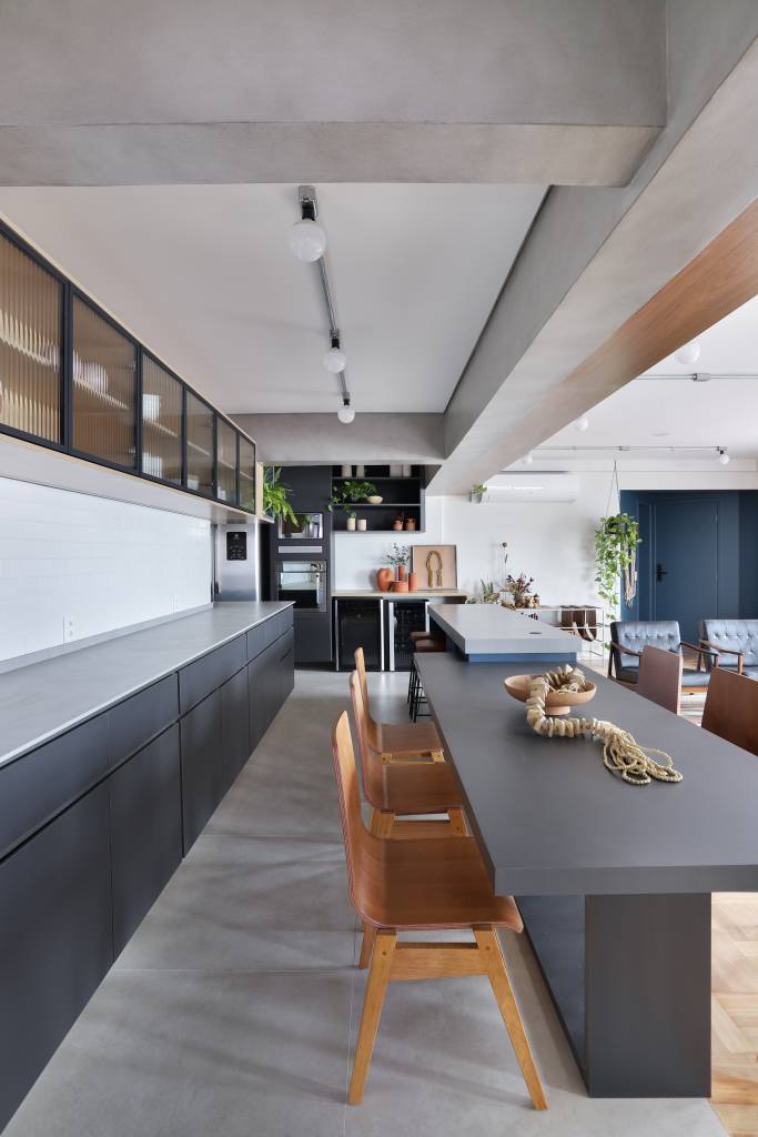 Apê de 180m² ganha color block azul na entrada e área de descompressão. Projeto de Studio 92 Arquitetura. Na foto, cozinha integrada com marcenaria e bancada cinzas.