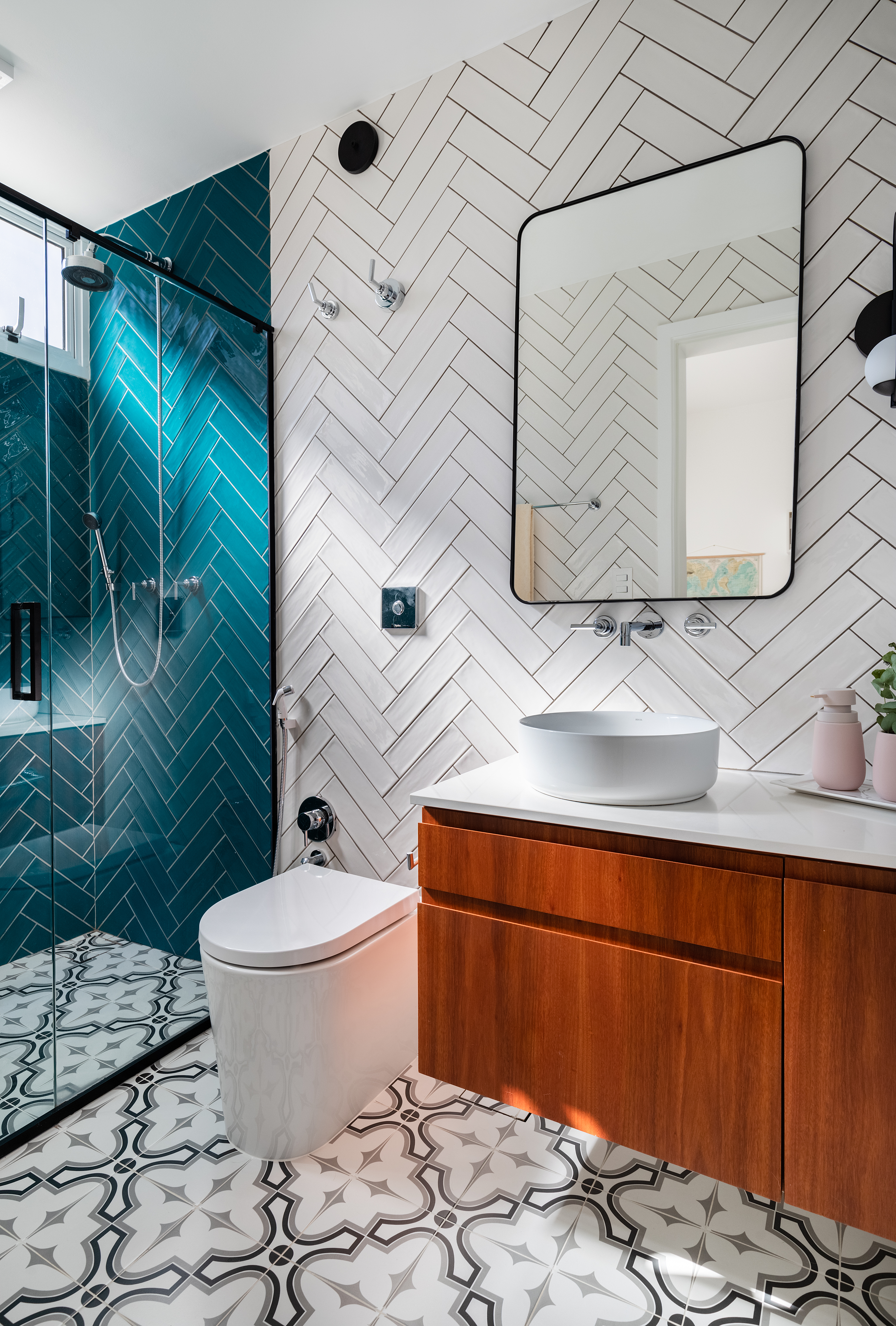 Projeto de Adriana Bersou. Na foto, banheiro com piso de ladrilhos e parede de azulejos brancos e azuis.