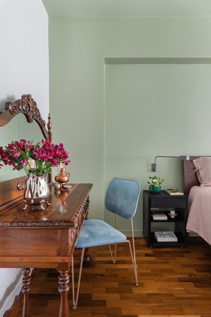 Projeto de Adriana Bersou. Na foto, quarto com parede verde e mesa de home office vintage de madeira.
