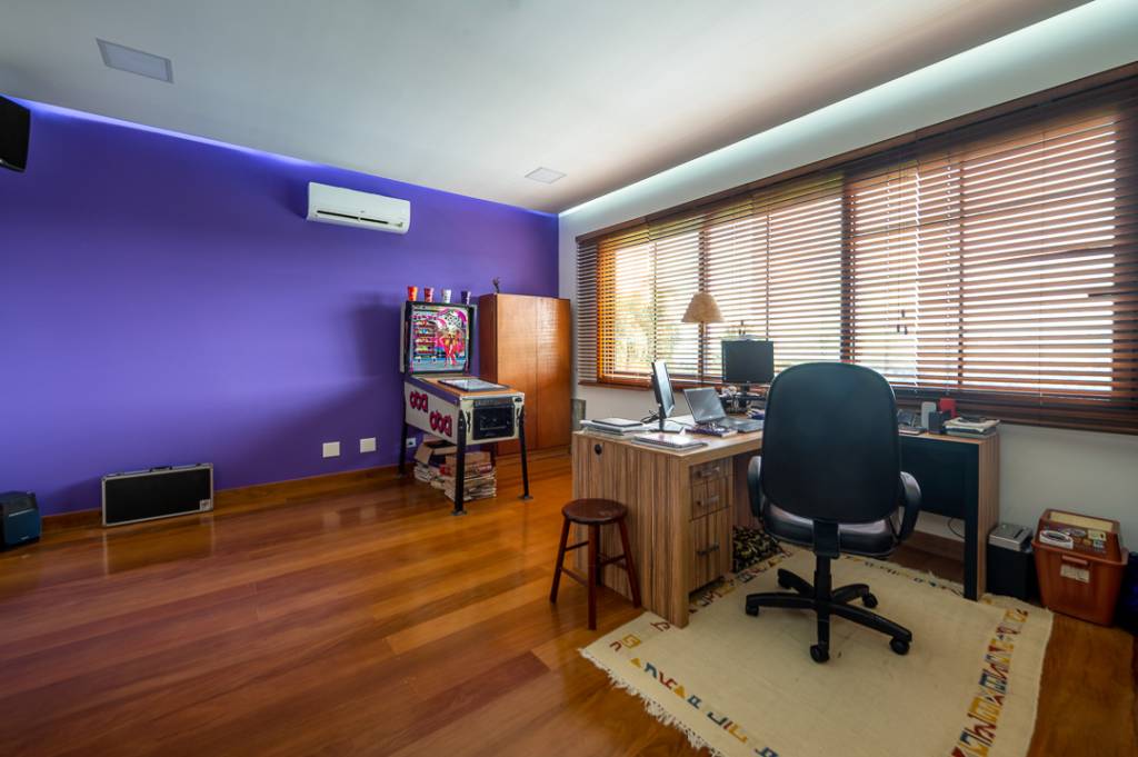Casa de campo de 450 m² tem dois estúdios e vista para a natureza. Projeto de Geração Arquitetura. Na foto, escritório com toca-discos e bandeiras. Fliperama e parede roxa.