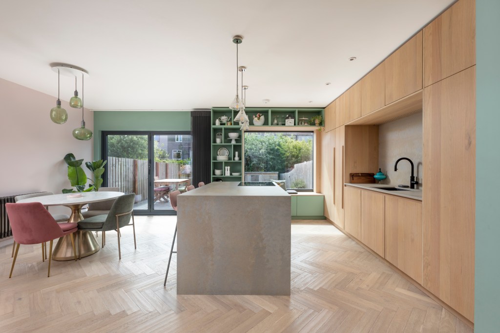 Projeto de AGORA architecture + design. Na foto, cozinha integrada com eletrodomésticos na marcenaria e estante verde.
