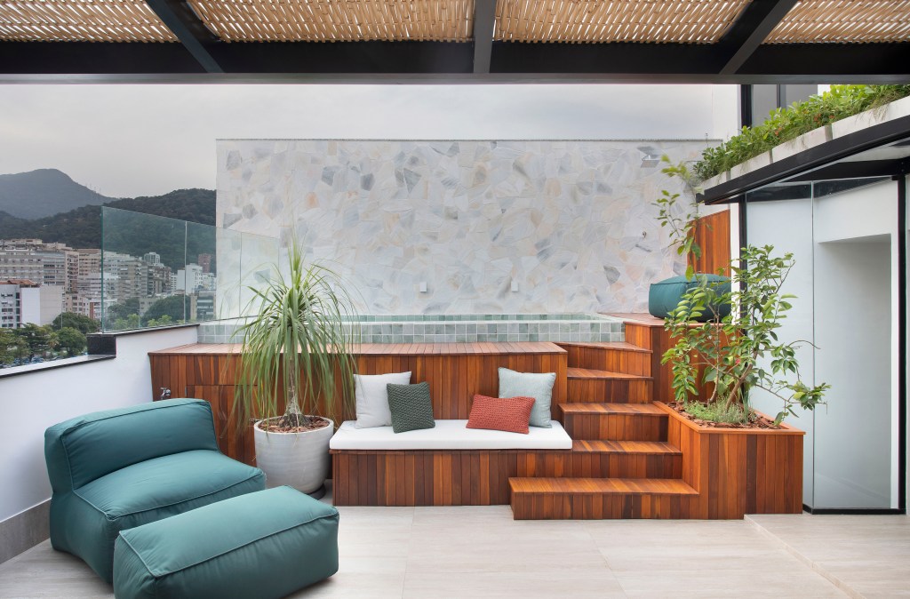 Cobertura triplex de 300m² ganha piscina com deck e cozinha verde menta. Projeto de Beta Arquitetura,. Na foto, área externa com deck de madeira e piscina.