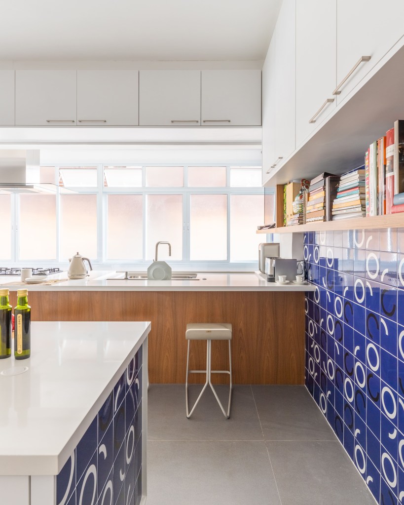 Cozinhas contemporâneas: verde e azul são tendência no cômodo. Projeto de BMA Studio. Na foto, cozinha com parede de azulejo azul.
