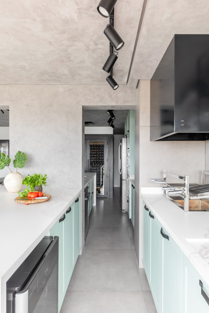 Cozinhas contemporâneas: verde e azul são tendência no cômodo. Projeto de BMA Studio. Na foto, cozinha com armários verdes claros.