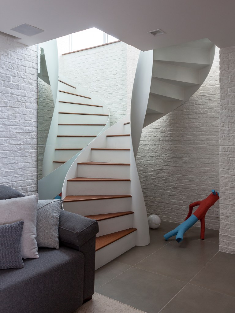Dúplex de 150 m² ganha área externa com jacuzzi e escada escultural. Projeto de Felipe Carolo. Na foto, escada escultural com parede de espelho.