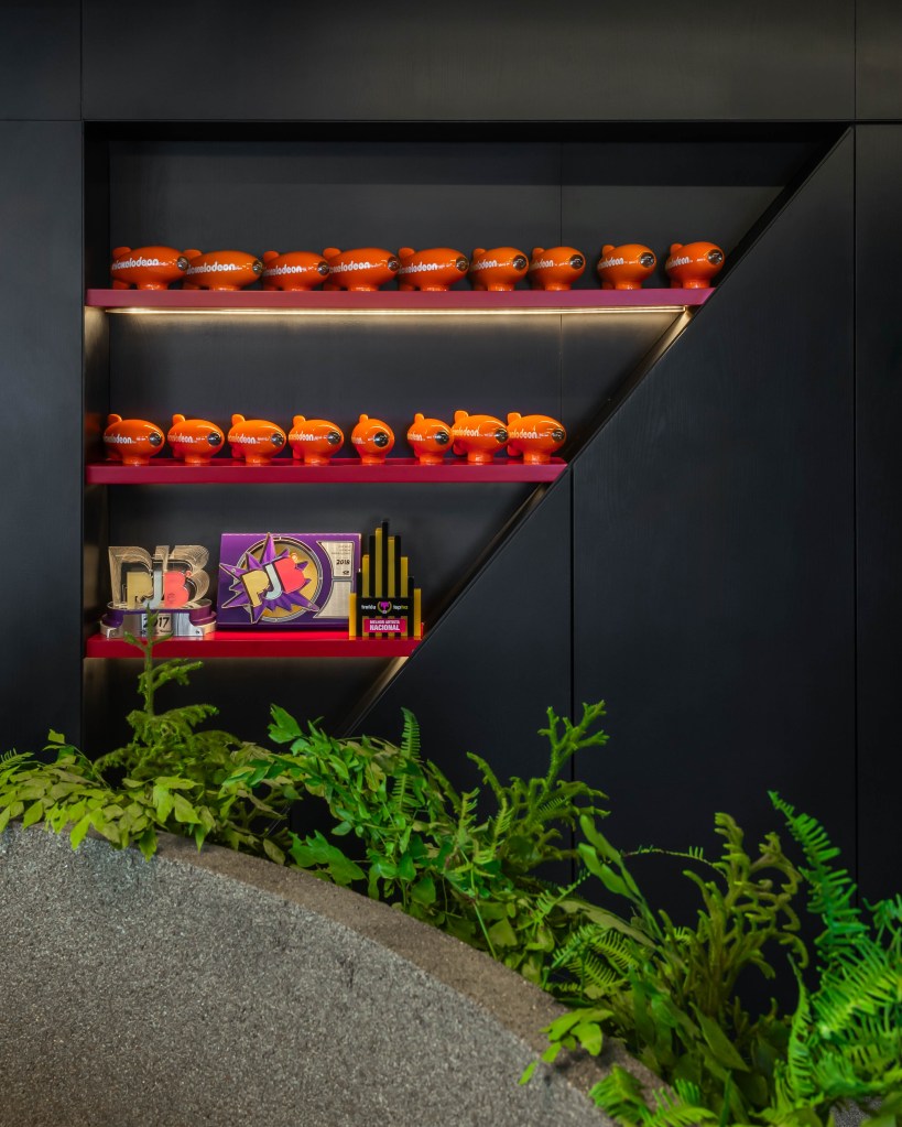 Conheça com exclusividade o novo escritório de 500m² de Luan Santana. Na foto, estante de marcenaria preta com prêmios.