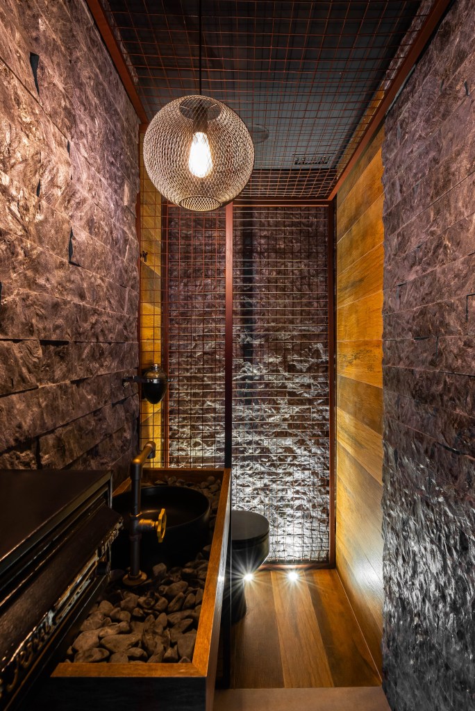 Conheça com exclusividade o novo escritório de 500m² de Luan Santana. Na foto, banheiro industrial com parede revestida de tijolinhos.