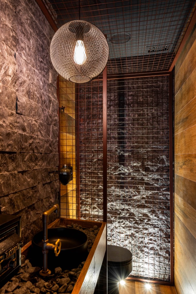 Conheça com exclusividade o novo escritório de 500m² de Luan Santana. Na foto, banheiro industrial com parede revestida de tijolinhos.